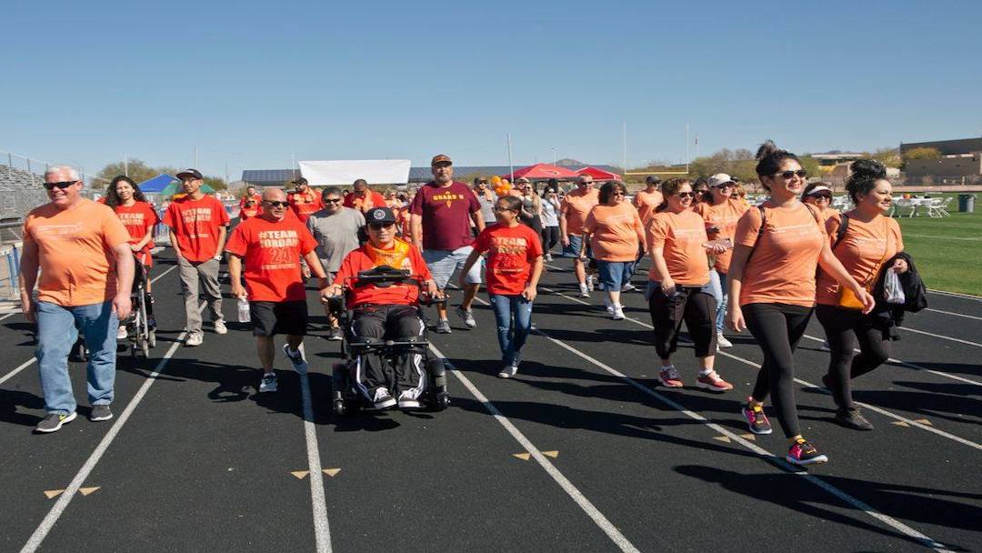 Participants in their orange and red t-shirts walking during the 2020 Walk-Run-N-Roll event