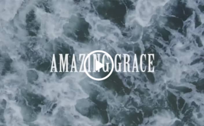 Text that reads AMAZING GRACE with a ocean background