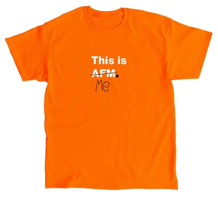Orange t-shirt with This is AFM in white text. AFM is crossed out with black ink and beneath is the word Me in black text.