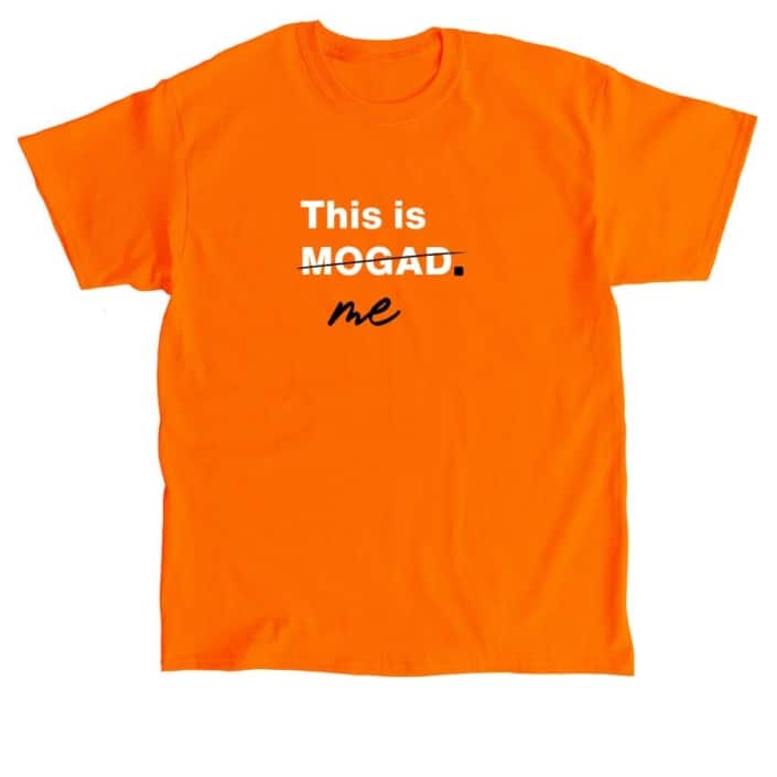 Orange t-shirt with This is MOGAD in white text. MOGAD is crossed out with black ink and beneath is the word Me in black text.
