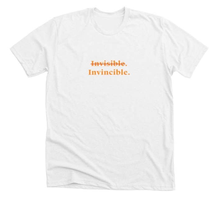 White t-shirt with word "invisible" crossed out and beneath the word "invincible" in orange text